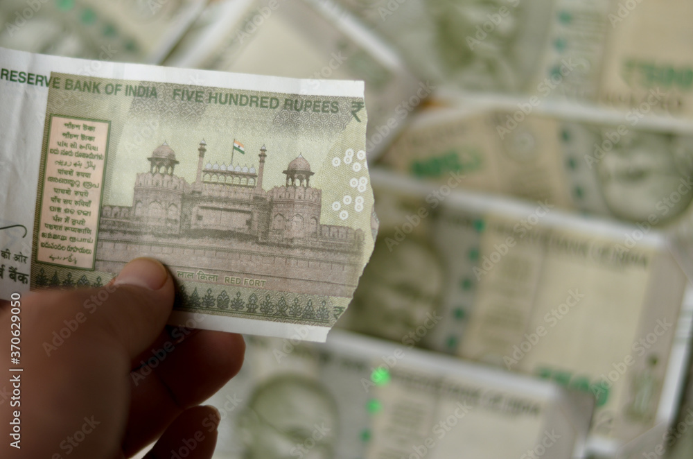 A woman hand holding a torn new Rs 500 Rupees Indian Currency notes ...