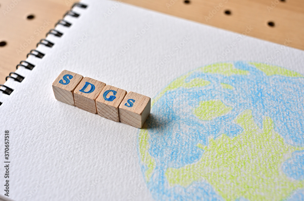 Sdgs サスティナブルディベロップメントゴールズ のスタンプが押された木製キューブが地球のイラストの上に置かれている Wall Mural Hogehoge511