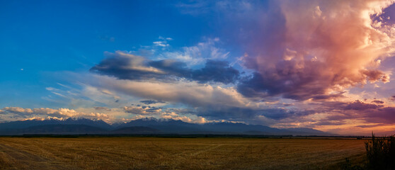 Wall Mural - bright sunlight shining through the clouds against the backdrop of a breathtaking evening sky at sun