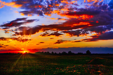 Wall Mural - bright sunlight shining through the clouds against the backdrop of a breathtaking evening sky at sun