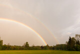 Fototapeta Tęcza - doppelter Regenbogen über einer Wiese auf dem Land