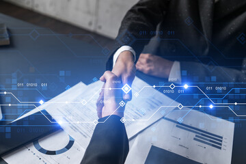 double exposure of two businesspeople handshake and binary technology hologram drawing background. c