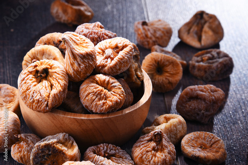 Fotografía Composition with bowl of dried figs on wooden table