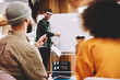 © BullRun - Successful male coach conducting seminar explaining information standing near white flipchart in university.Creative positive leader talking about business plan with students during workshop