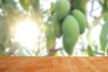 wood plank on blurred of green mango fruit background,