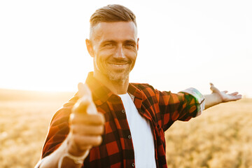 Wall Mural - Image of pleased man holding copyspace and pointing finger at camera