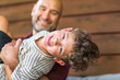 © digitalskillet1 - Hispanic father sitting and hugging his son.