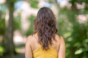 Portrait of a rear view of a woman standing in a forest.