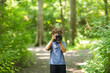 © digitalskillet1 - Young boy taking photo in the forest.