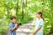 © digitalskillet1 - Young boy taking photo of his sister in the forest.