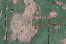 
Closeup Of An Old Wooden Door With Peeling Green Paint And Rusty Nails As A Background