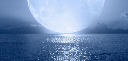 Fotobehang - Night sky with blue full moon in the clouds on the fore ground calm blue sea 