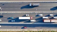 Aerial View Of A Two-lane Expressway Or Two-lane  Bridge Freeway At The Sunset. Vehicles And Commercial Trucks Can Be Seen.