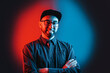 © _KUBE_ - Neon lights. Portrait of a man in a shirt, glasses and cap, with a beard, posing with his arms crossed. Red and blue circle in black background