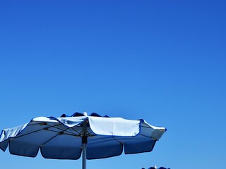 blue beach umbrellas in the sea of a liguria