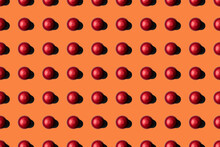 Top View Of Red Coffee Pods Placed In Even Rows As Seamless Pattern On Orange Background