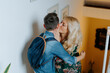 © Jake Jakab/ADDICTIVE STOCK - Content mother gently kissing teenage son with school backpack while hugging together on steps in cozy modern house