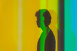 © Javier Bravo/ADDICTIVE STOCK - Side view of shadow of young male with curly hair standing in studio with neon lights