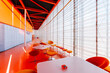 © Javier Bravo/ADDICTIVE STOCK - Interior of vivid cafe with contemporary tables and chairs placed on shiny orange floor