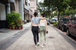 © Juan Alberto Ruiz/ADDICTIVE STOCK - Happy slim young Asian female in casual clothes embracing friends shoulder while walking together along busy street in Taipei