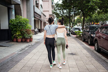 Happy Slim Young Asian Female In Casual Clothes Embracing Friends Shoulder While Walking Together Along Busy Street In Taipei