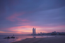 Silhouettes Of Contemporary Skyscrapers Located On Seafront Of Xiamen City Against Colorful Sunset Sky In Evening Time In China