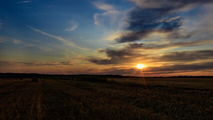 Wall Mural - Sunset over agricultural field against cloudy sky in Möckmühl, Germany