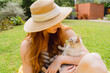 © Westend61 - Happy young woman holding cat at yard during sunny day