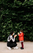 © Westend61 - Mother and daughter wearing masks while playing clapping game outdoors