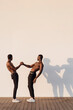 © Westend61 - Young shirtless man greeting while standing by white wall with shadow