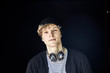 © Westend61 - Portrait of young man with headphones against black background