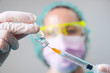 © Westend61 - Close-up of dentist's hands holding coronavirus vaccine and syringe in clinic