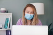 © Westend61 - Businesswoman wearing face mask using laptop in office