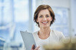 © Westend61 - Happy female manager holding clipboard in factory