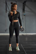 © Westend61 - Confident female athlete with braided hair lifting dumbbells in health club