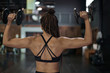 © Westend61 - Female athlete with braided hair lifting dumbbells in health club