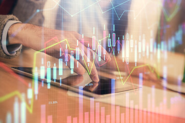 Double exposure of forex graph drawing and man and woman working together holding and using a mobile device. Trade concept.