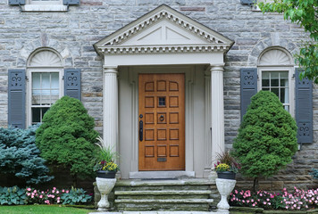 Wall Mural - Portico front door entrance of older stone faced house with shutters around the windows