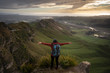 Young woman with backpack opening her arms at the top of Te Mata Peak, Hawke's Bay. New Zealand