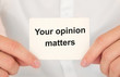 © Sinfebeth - Man's hands take a card with words Your opinion matters, finance and business concept.