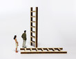 © Hyejin Kang - A miniature man and a miniature woman standing in front of another ladder.