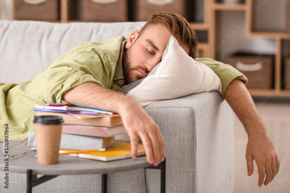 Tired male student sleeping at home