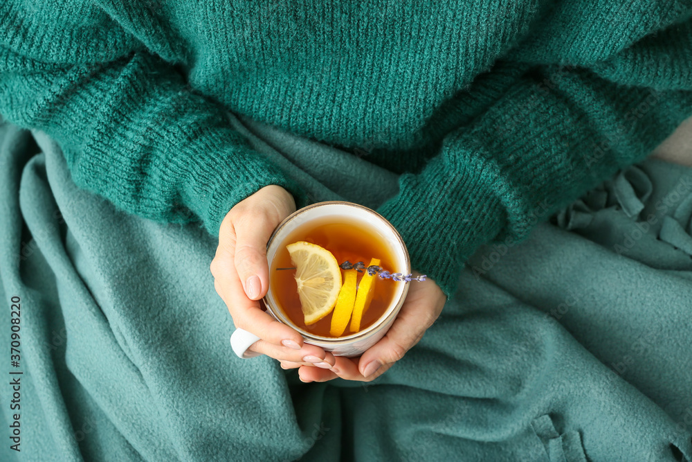 Woman with cup of hot tea at home