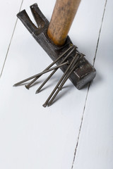 An old hammer and a handful of nails. On white background.