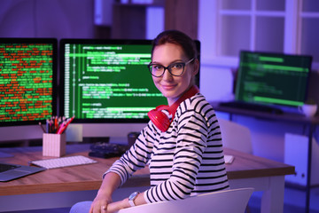 Female programmer working in office at night