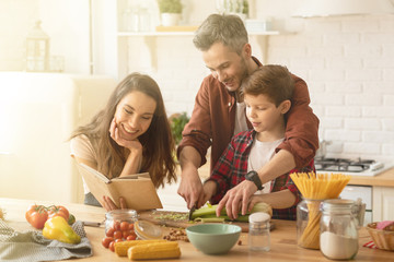 Caring parents and child cooking at home kitchen