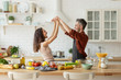 © deniskomarov - Happy laughing wife and husband dancing on kitchen