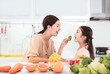 © Tom Wang - happy Mother and child daughter  preparing and eating the vegetables and fruit