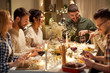 © Syda Productions - holidays, celebration and people concept - happy smiling friends having christmas dinner party at home in evening