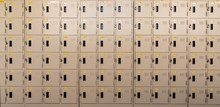 Closeup Beige Locker With Lock And Numbered Yellow Tags At Locker Room. Locker For Safety And Security Storage. Row Of Locker With Locked Door Background.